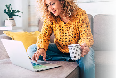 Woman using laptop with a cup of coffee